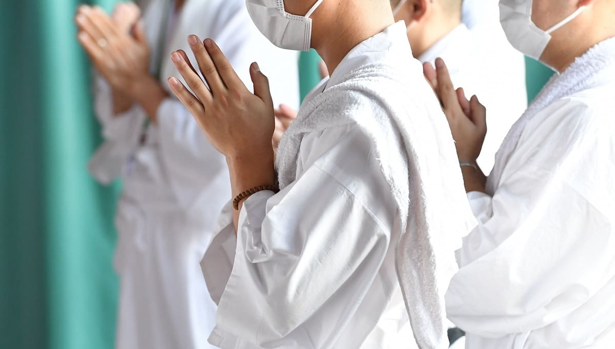 白い服を着て盲目的な信仰で祈る人々